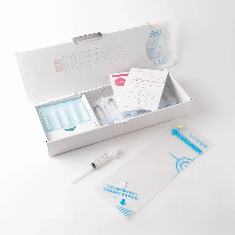 Open at-home insemination kit with syringes, storage containers, and instruction sheets.