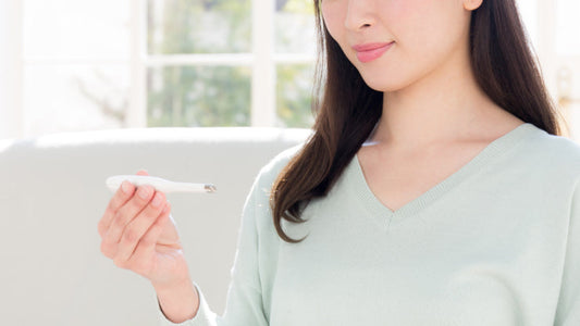 Woman indoors holding an at-home fertility or insemination test kit