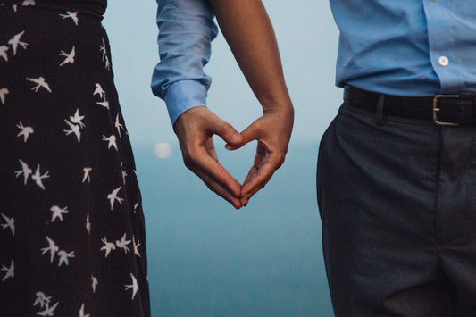 Couple forming a heart shape with hands, symbolizing love and fertility journey